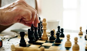Person moving a chess piece on a chess board